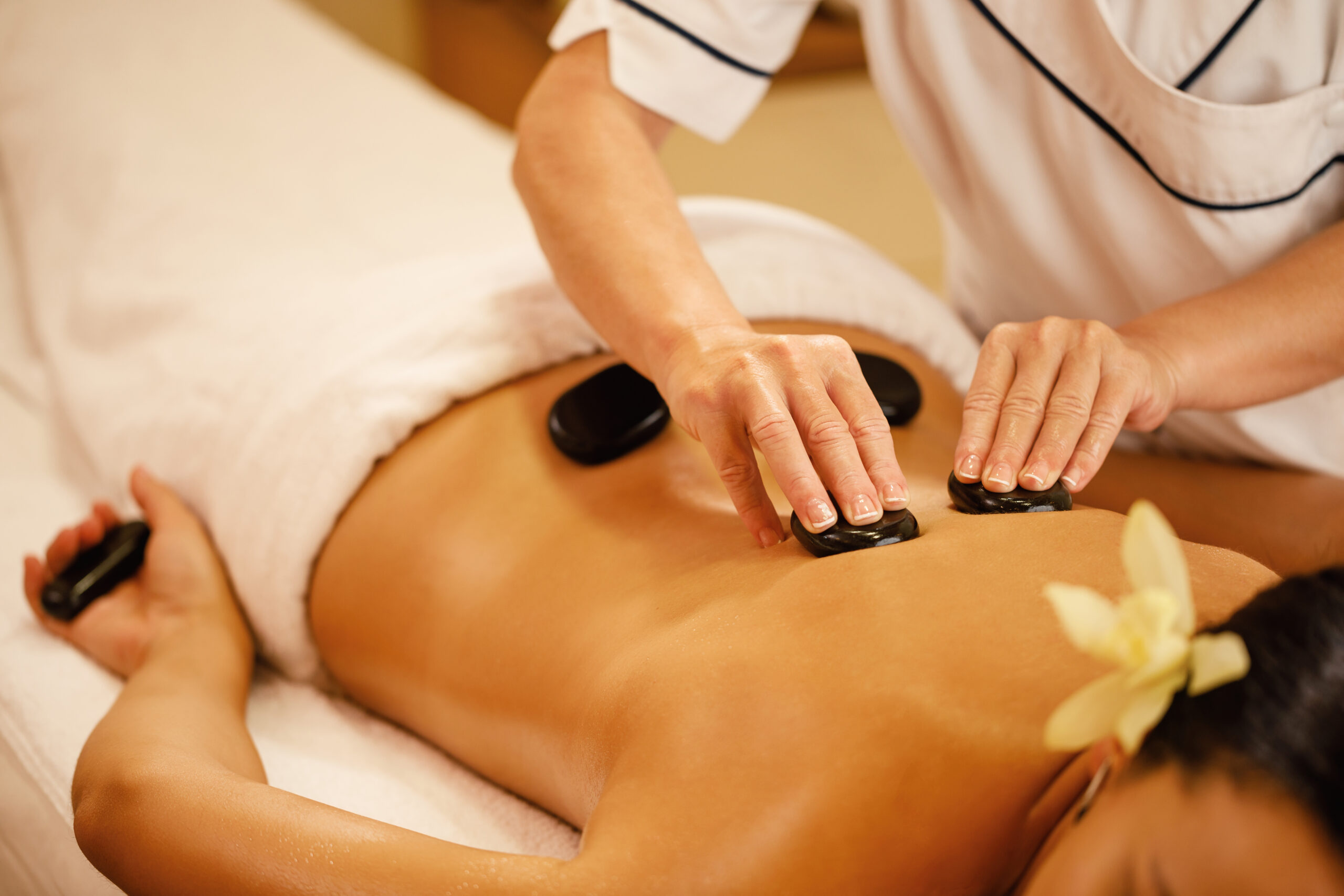 Unrecognizable woman relaxing during lastone therapy at wellness spa.